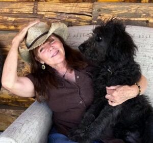 woman holding black poodle